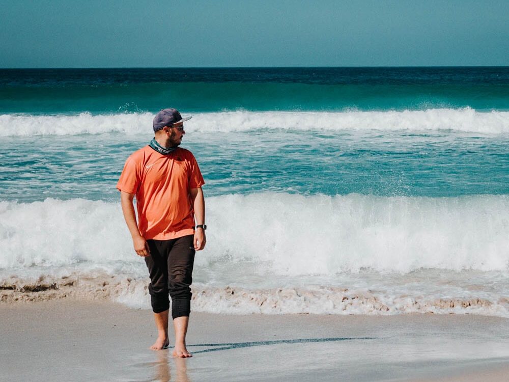 guy walking on beach in cape point